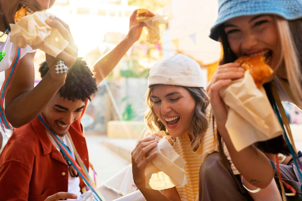 Young adults enjoying a lively block party with food, drinks, and music, capturing the vibrant spirit of a global food festival in an urban setting.